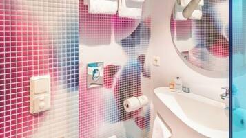 A modern bathroom with a toilet, sink, and mirror.