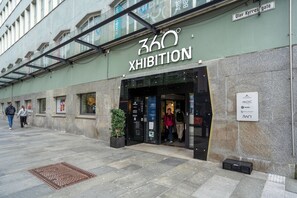 The exterior of the 360 XHIBITION building with a glass entrance and a sign indicating it is a MoIIC and Unilock building. - Prize by Radisson, Xhibition Bergen City (Bergen)