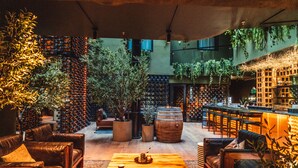 A modern lounge area with leather sofas, a wooden coffee table, and a bar with a wine rack.