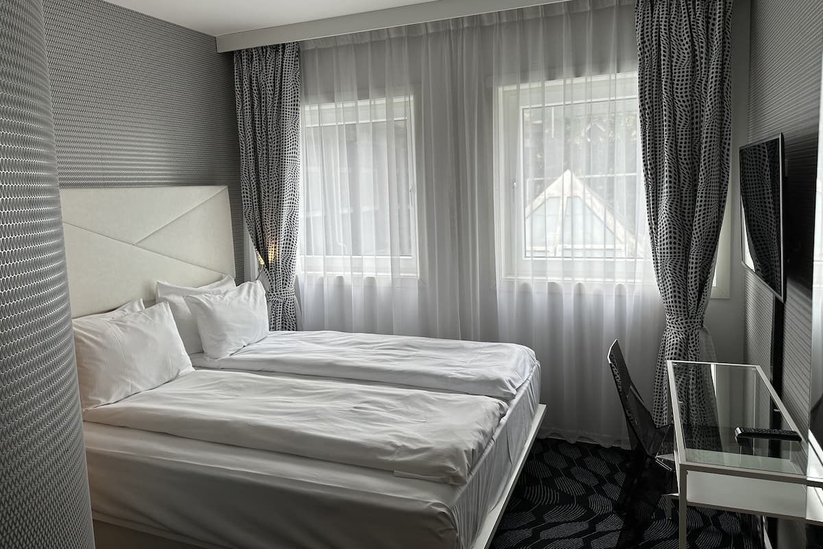 Une chambre d’hôtel avec un lit, un bureau et une télévision.