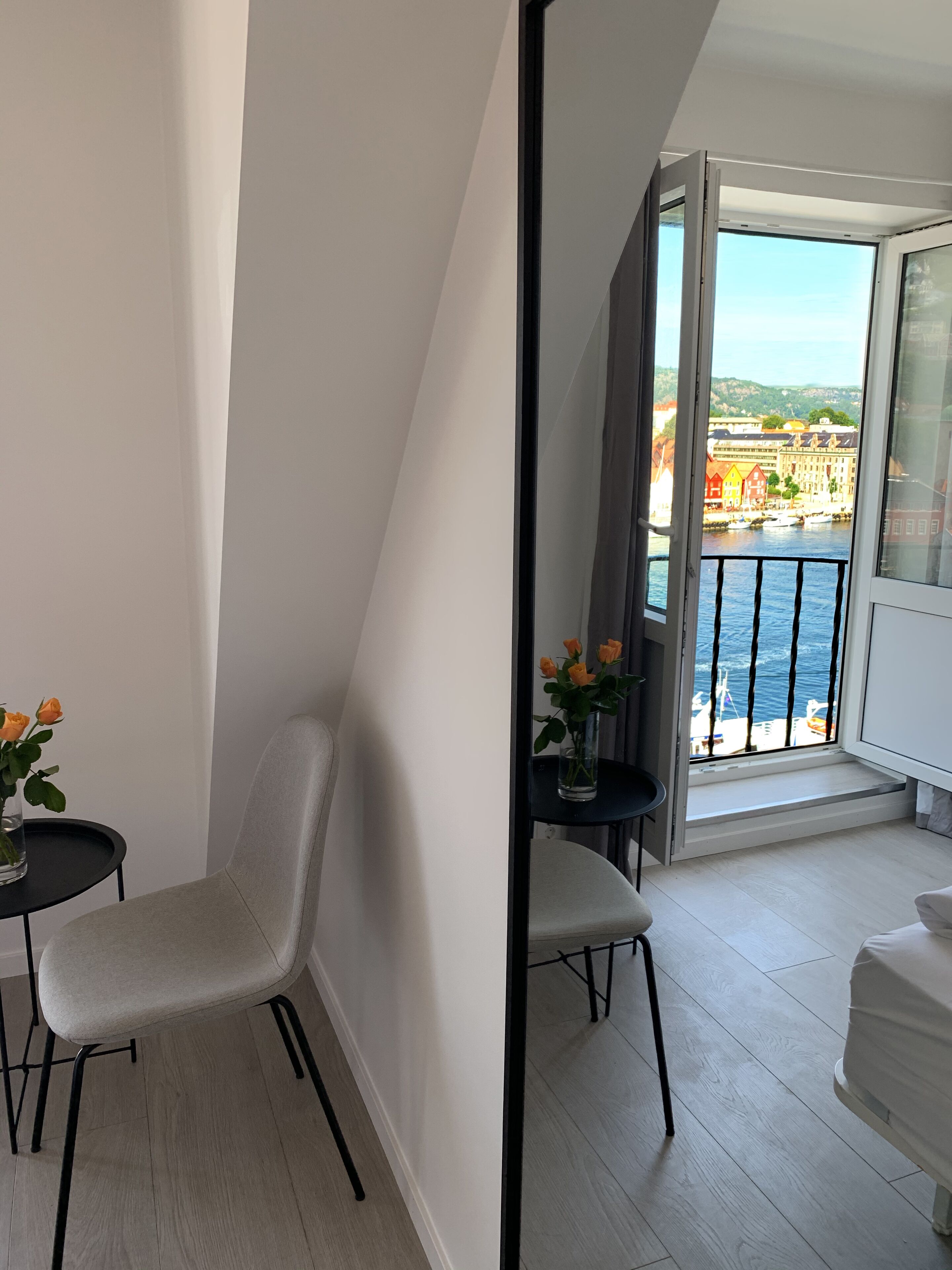A modern apartment with a balcony overlooking a waterfront.