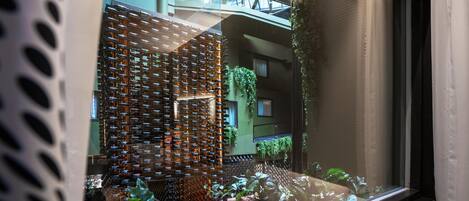 A modern interior with a patterned wall, a staircase, and greenery.