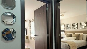 Une chambre à coucher comprenant un lit, une armoire et trois miroirs hexagonaux accrochés au mur.