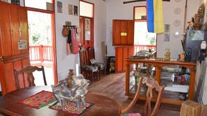 A wooden dining area with a table, chairs, and a decorative metal sculpture. - Finca Cafetera San Rafael (Santa Marta)