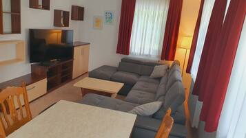 Basic-Apartment, 1 Schlafzimmer | Wohnbereich | 55-Zoll-Flachbildfernseher mit Kabelempfang, Fernseher