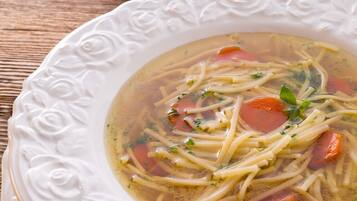 Un tazón de sopa con fideos y verduras.