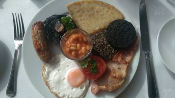 Plat de menjar per esmorzar amb ous, botifarreta, botifarra negra, fesols cuits i torrades.