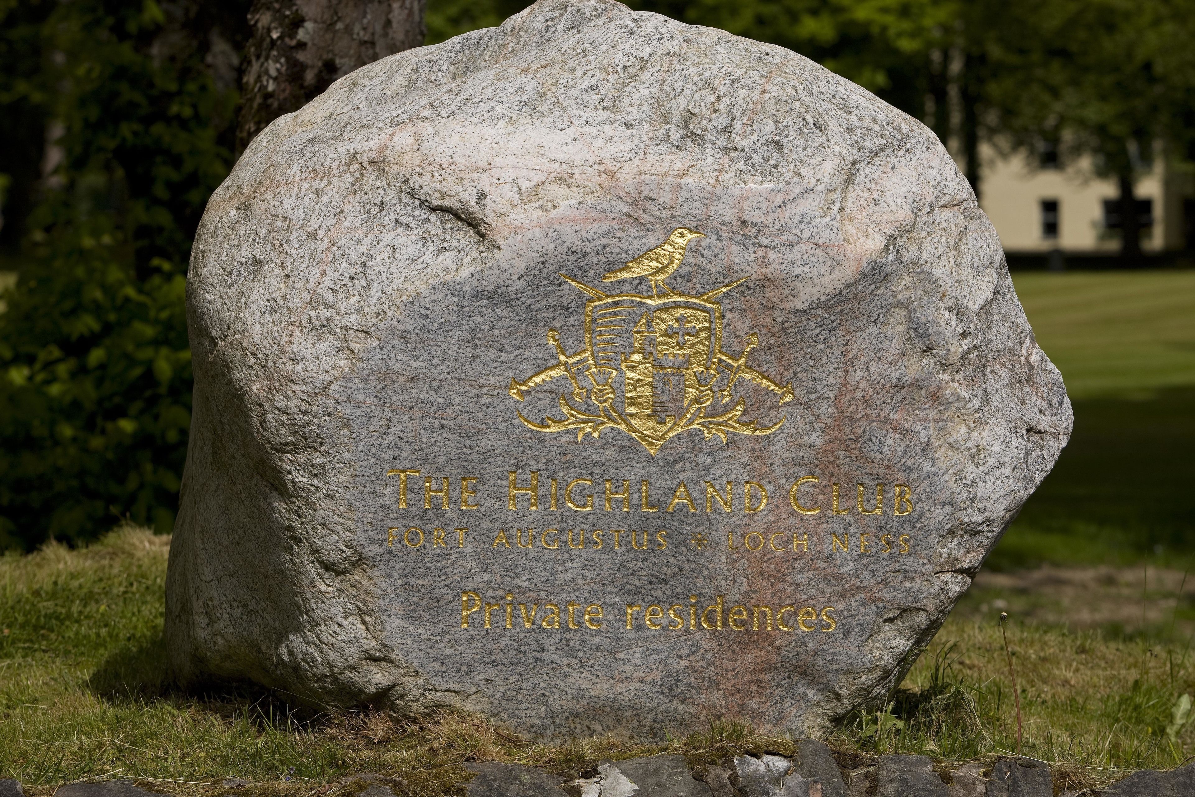 A large stone with the Highland Club logo and text indicating private residences.