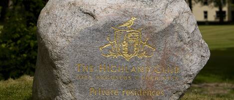 A large stone with the Highland Club logo and text indicating private residences.