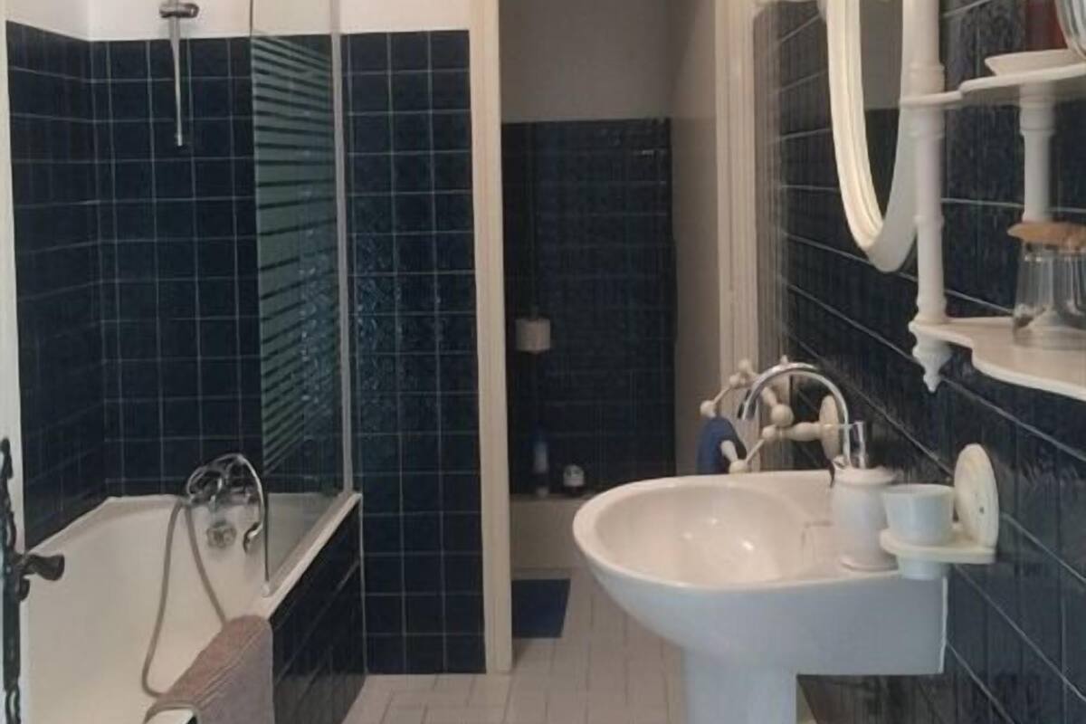 A bathroom with a bathtub, a sink, and a mirror.