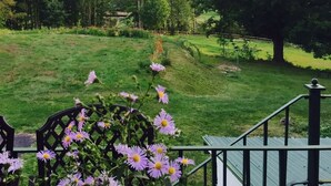 A view of a lush green landscape with a large tree and a hill in the background. - Georgian Garden Inn (Windham)