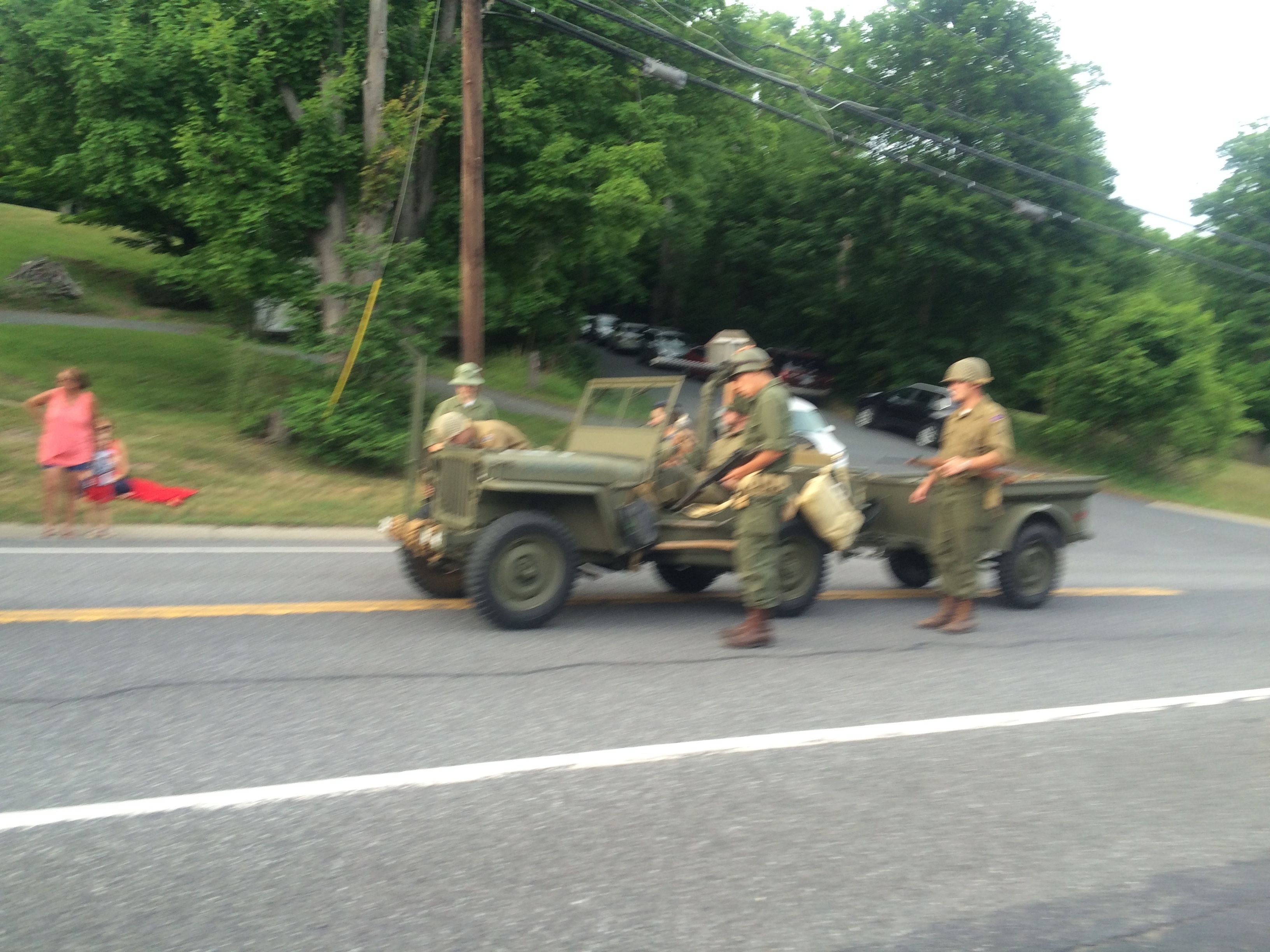 Ein Militärkonvoi mit Personal und Fahrzeugen auf einer Straße.
