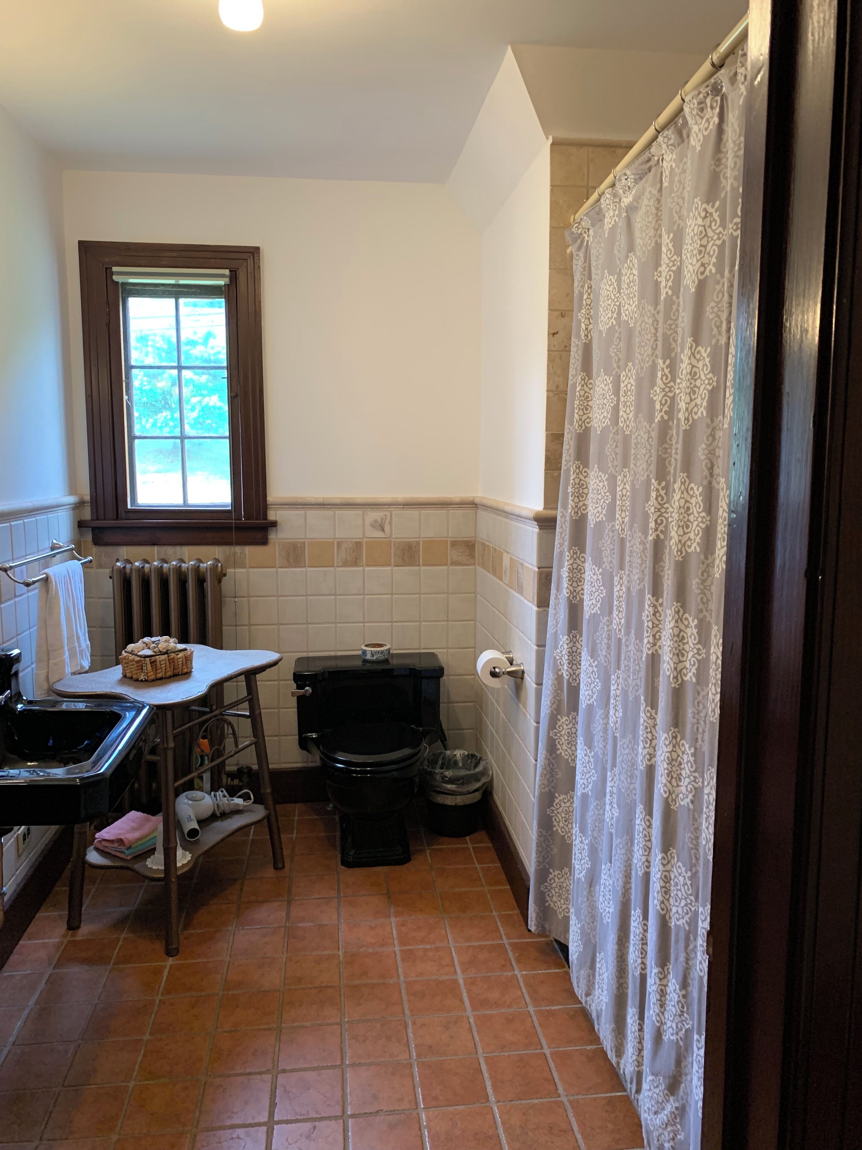A compact bathroom with a toilet, sink, and a window.