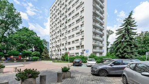 A multi-story residential building with balconies, a playground, and a parking area. - ShortStayPoland Aleje Jerozolimskie B13 (Warsaw)