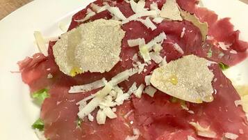 Ein Teller mit rohem Fleisch, geriebenem Käse und einer Garnitur.
