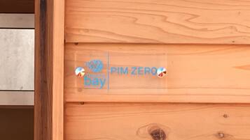 A wooden panel with a logo and text that reads "PIM ZERO bay".