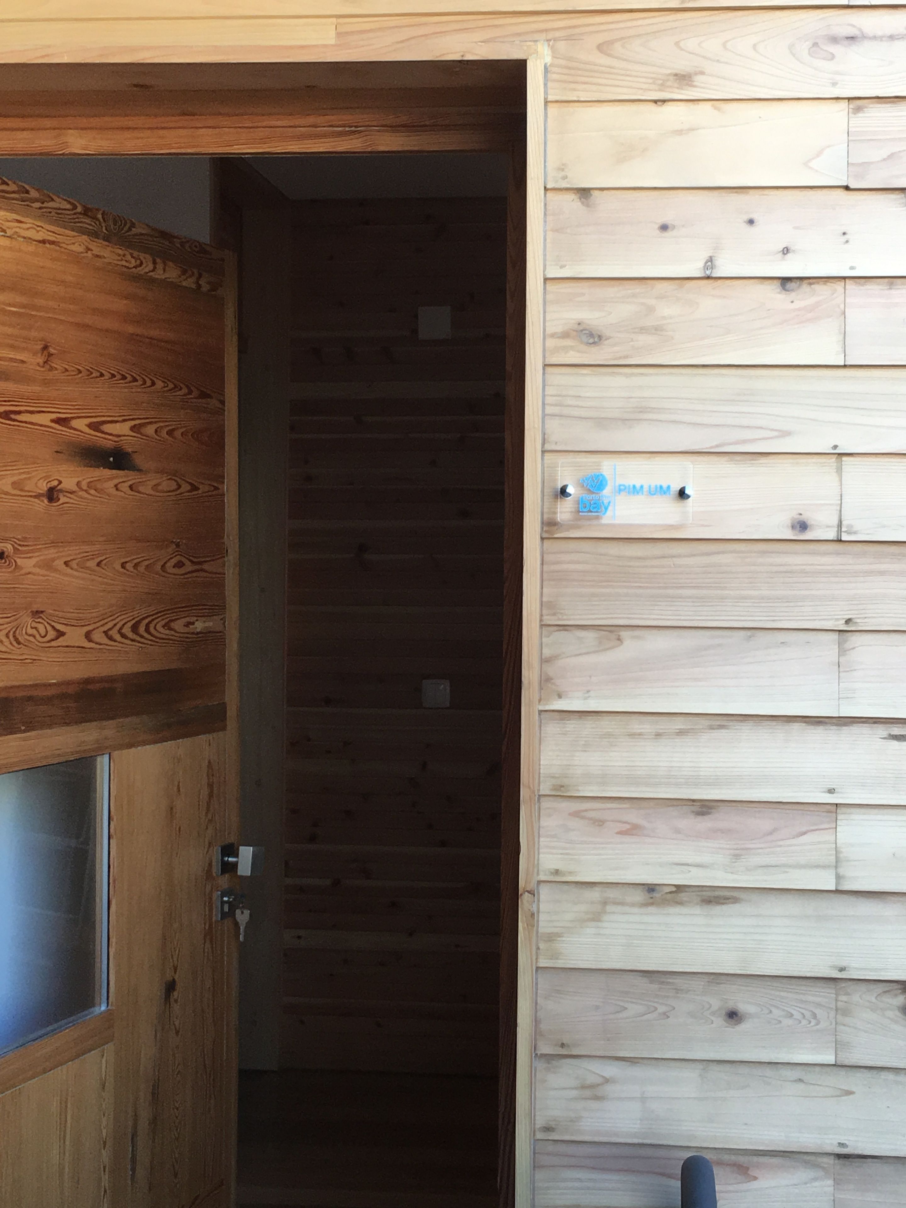 A wooden door with a sign that reads "PIM UM."