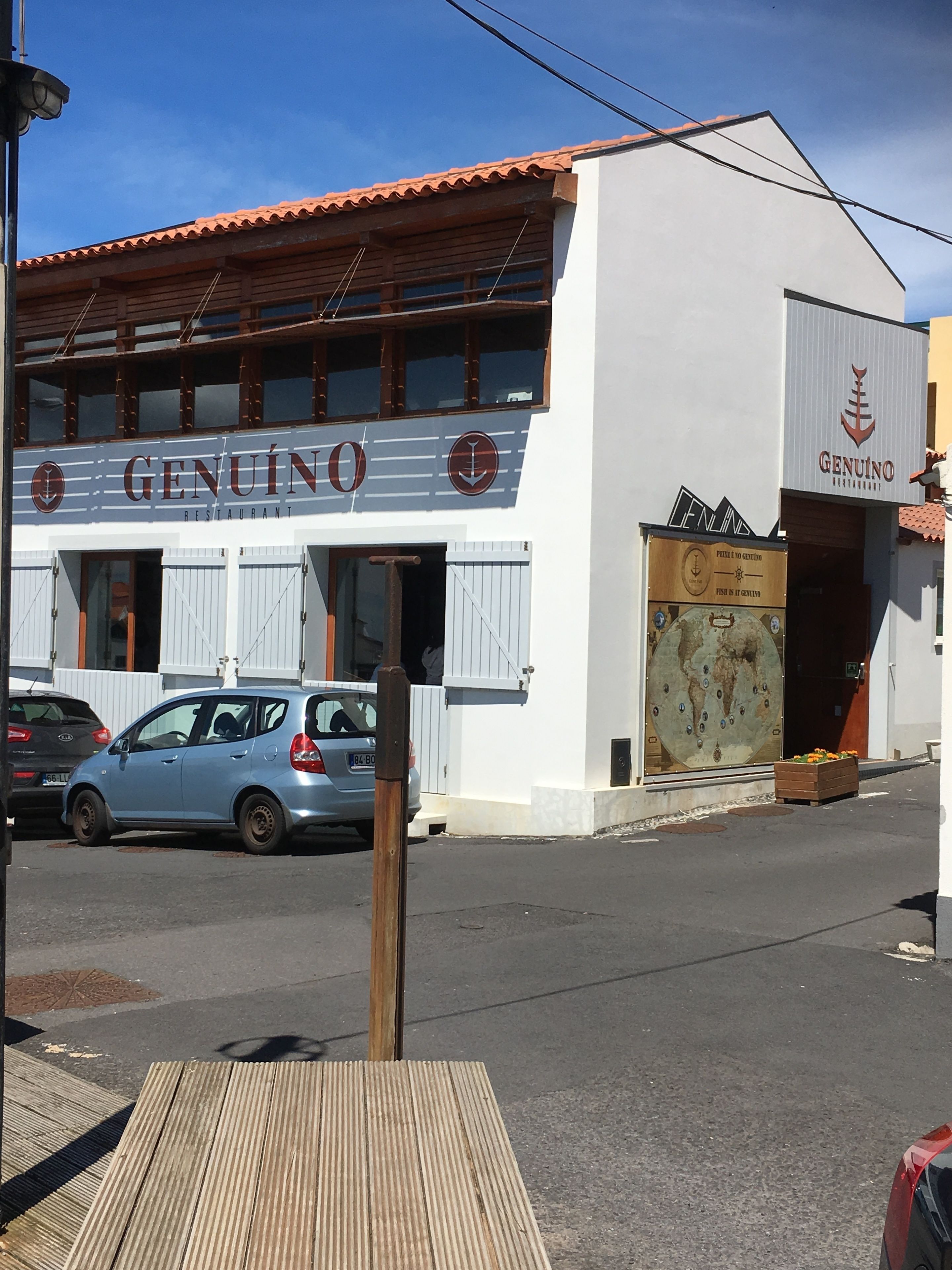 A building with a sign reading "GENUINO RESTAURANT" and a logo with an anchor.