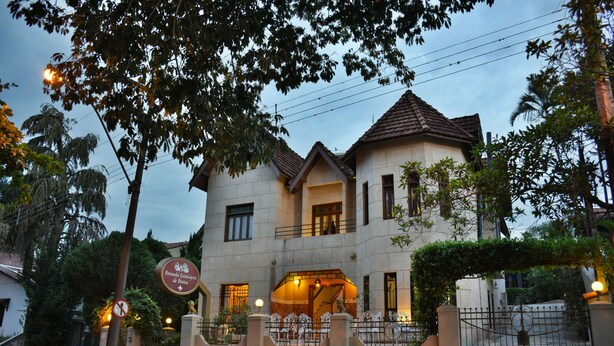 A two-story building with a gated entrance, a staircase leading to the upper floor, and a well-lit facade. - Pousada Estalagem de Brotas (Brotas)
