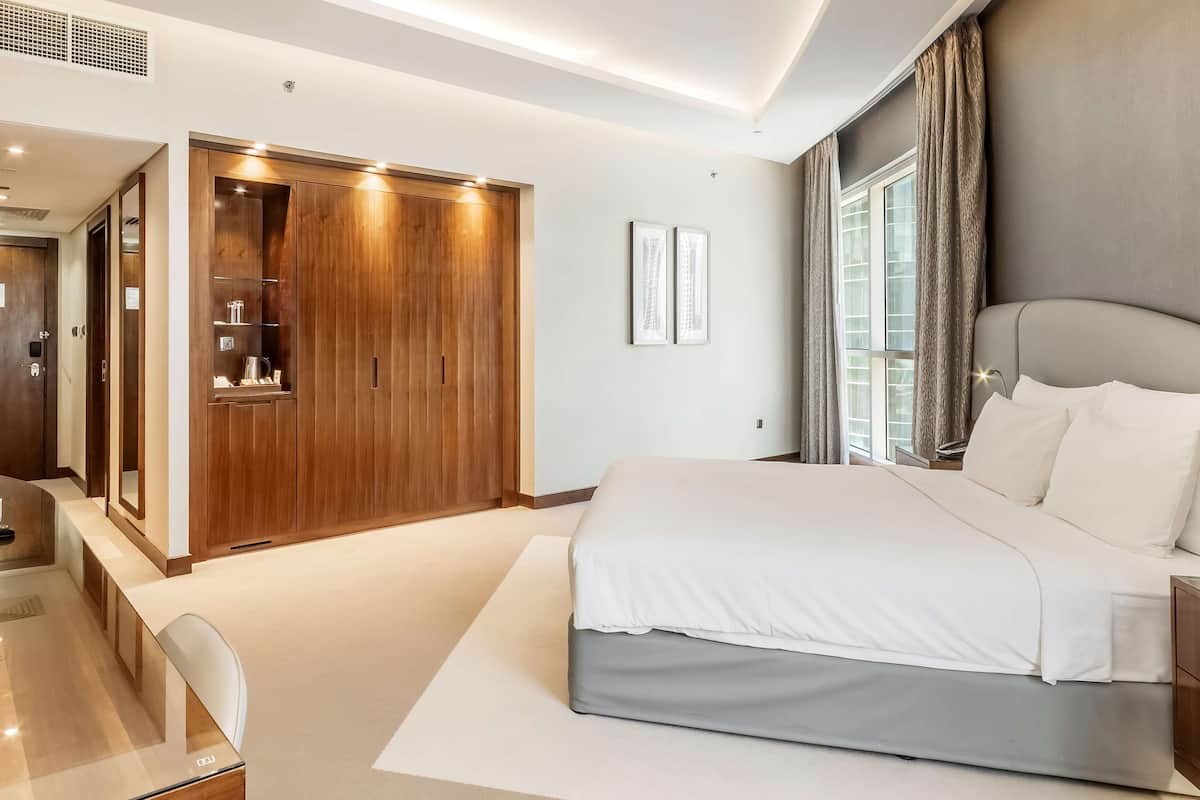 Ein modernes Schlafzimmer mit einem großen Bett, einem Kleiderschrank und einem Schreibtisch.