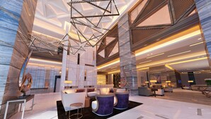 Eine großzügige Lobby mit modernen Möbeln, einem geometrischen Leuchten und einem Marmorboden.