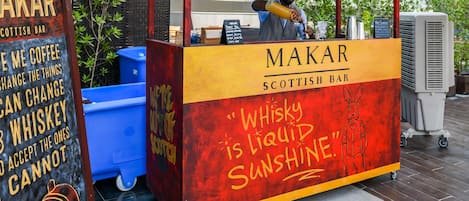 A mobile Scottish bar named Makar, featuring a whiskey sign and a menu board.