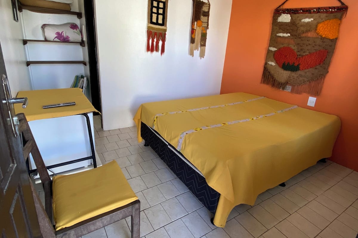 Ein Zimmer mit einem Bett, einem Schreibtisch und Regalen mit Kissen.