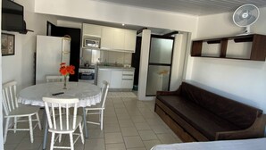 A compact living space with a dining area, kitchenette, and a sofa. - Pousada Aventura (Passo de Torres)