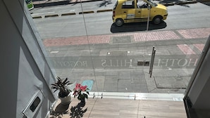 A hotel entrance with a clear view of the street outside, including a yellow taxi and a pedestrian crossing.
