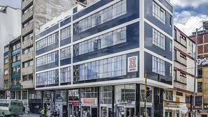 A multi-story hotel with a modern design, featuring large windows and a flat facade.