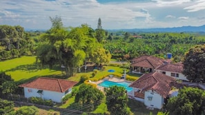 A residential area with houses, a swimming pool, and lush greenery. - Finca Hotel La Coqueta (Montenegro)