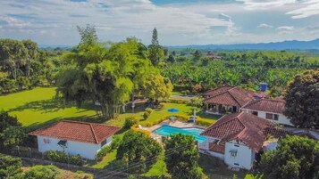 Un barrio residencial con casas, piscina y abundante vegetación.