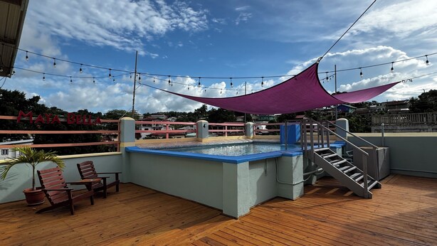A wooden deck with a pool table, chairs, and a staircase. - Maya Bella Downtown Hotel (San Ignacio)