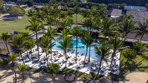 An aerial view of a resort with a central swimming pool surrounded by palm trees and lounge areas. - Portobello Resort & Safári (Mangaratiba)