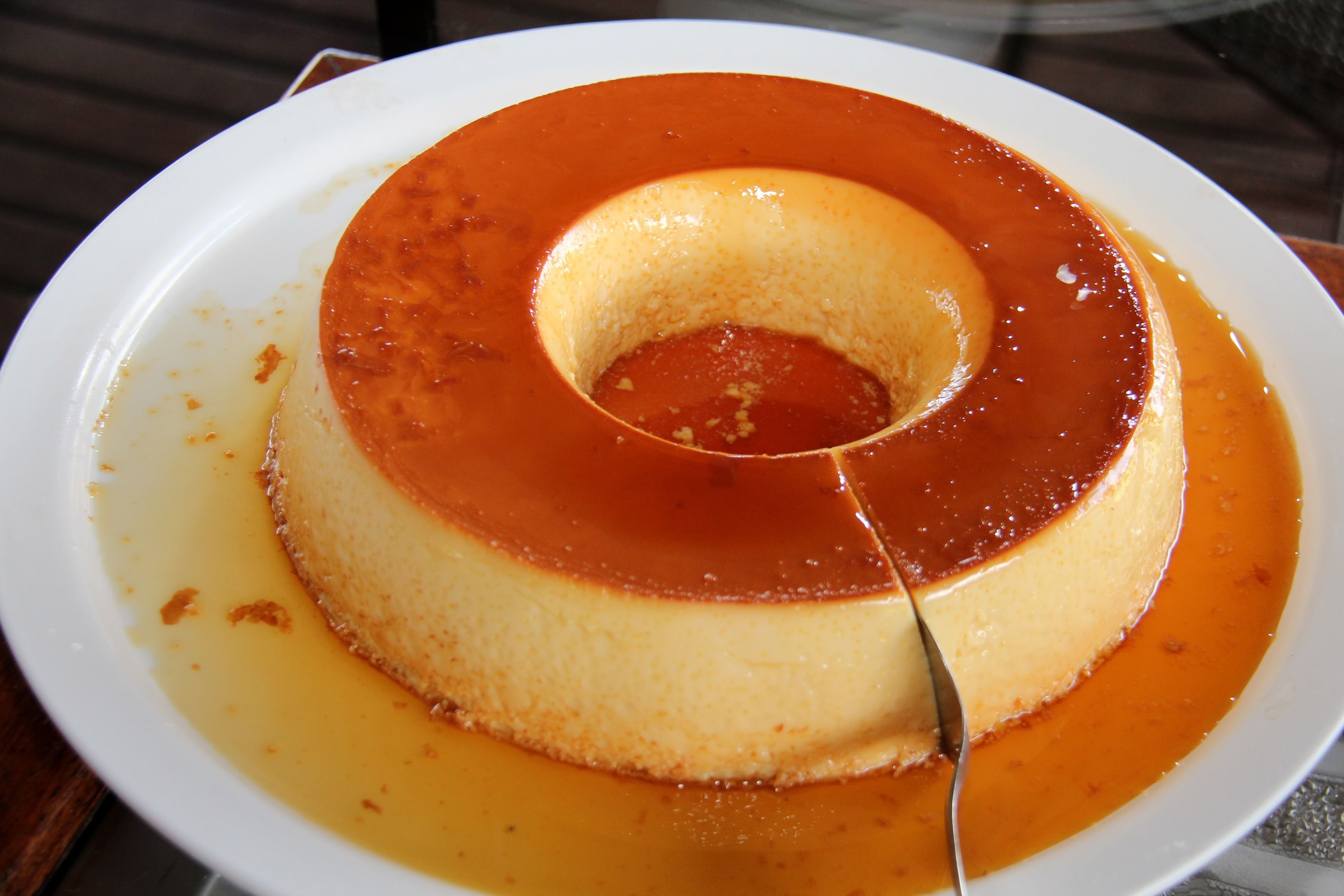 Eine Karamell-Füllung auf einem weißen Teller, umgeben von Karamellsauce.