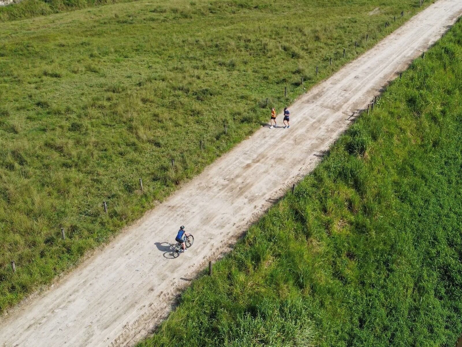 An aerial view of a dirt path through a grassy field.