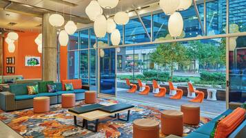 A modern lounge area with seating, a coffee table, and hanging pendant lights.