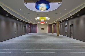 Un pasillo amplio con un suelo estampado, iluminación empotrada y un elemento decorativo central.