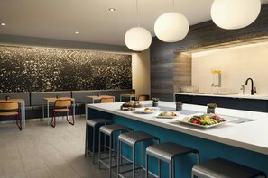 A modern bar area with a central island, bar stools, and a decorative wall.
