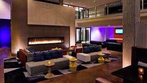 A modern lounge area with a fireplace, sofas, and a television.