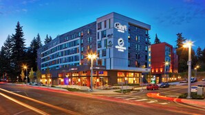 A modern hotel with multiple floors, a prominent logo, and a well-lit facade.