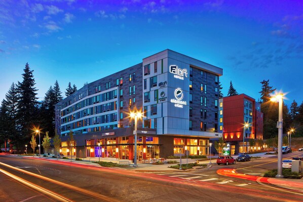 A modern hotel with multiple floors, a prominent logo, and a well-lit facade.