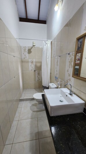 Ein Badezimmer mit Dusche, Toilette und Waschbecken.