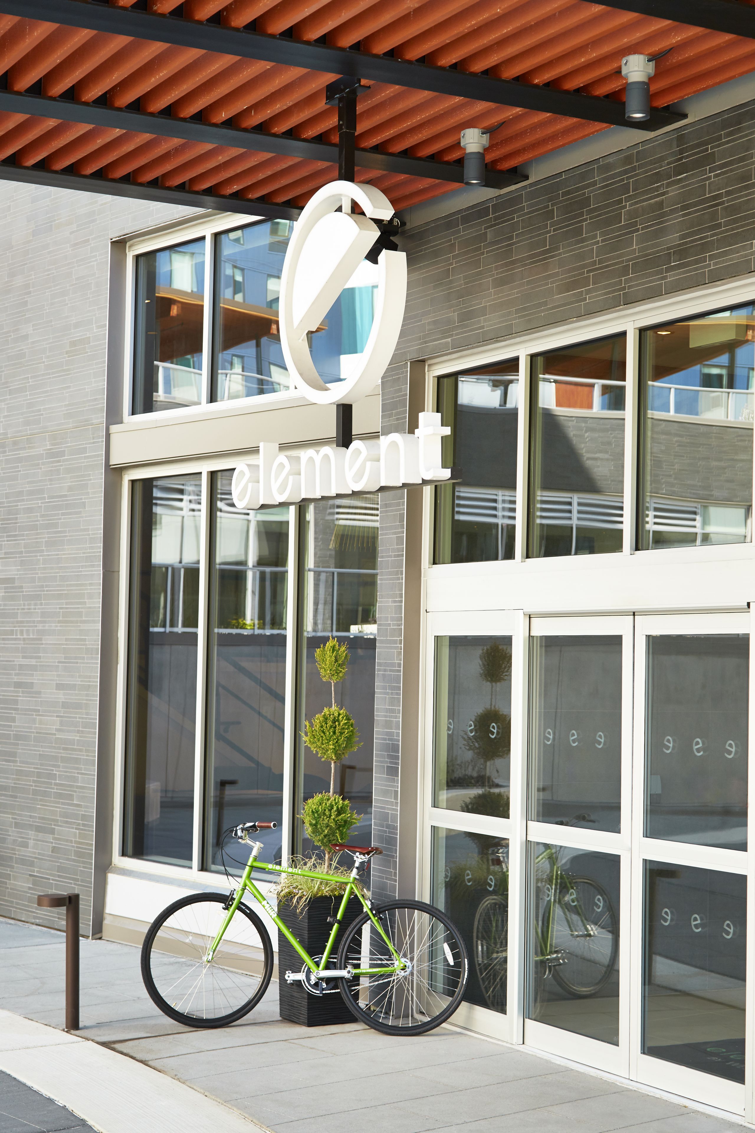 A modern building with a large glass window and a bicycle parked outside.