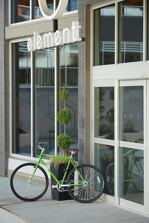 A green bicycle parked outside a building with a sign that reads "element".