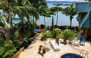 A tropical outdoor area with a pool, lounge chairs, and a view of the sea. - Cabinas Jimenez (Puerto Jiménez)