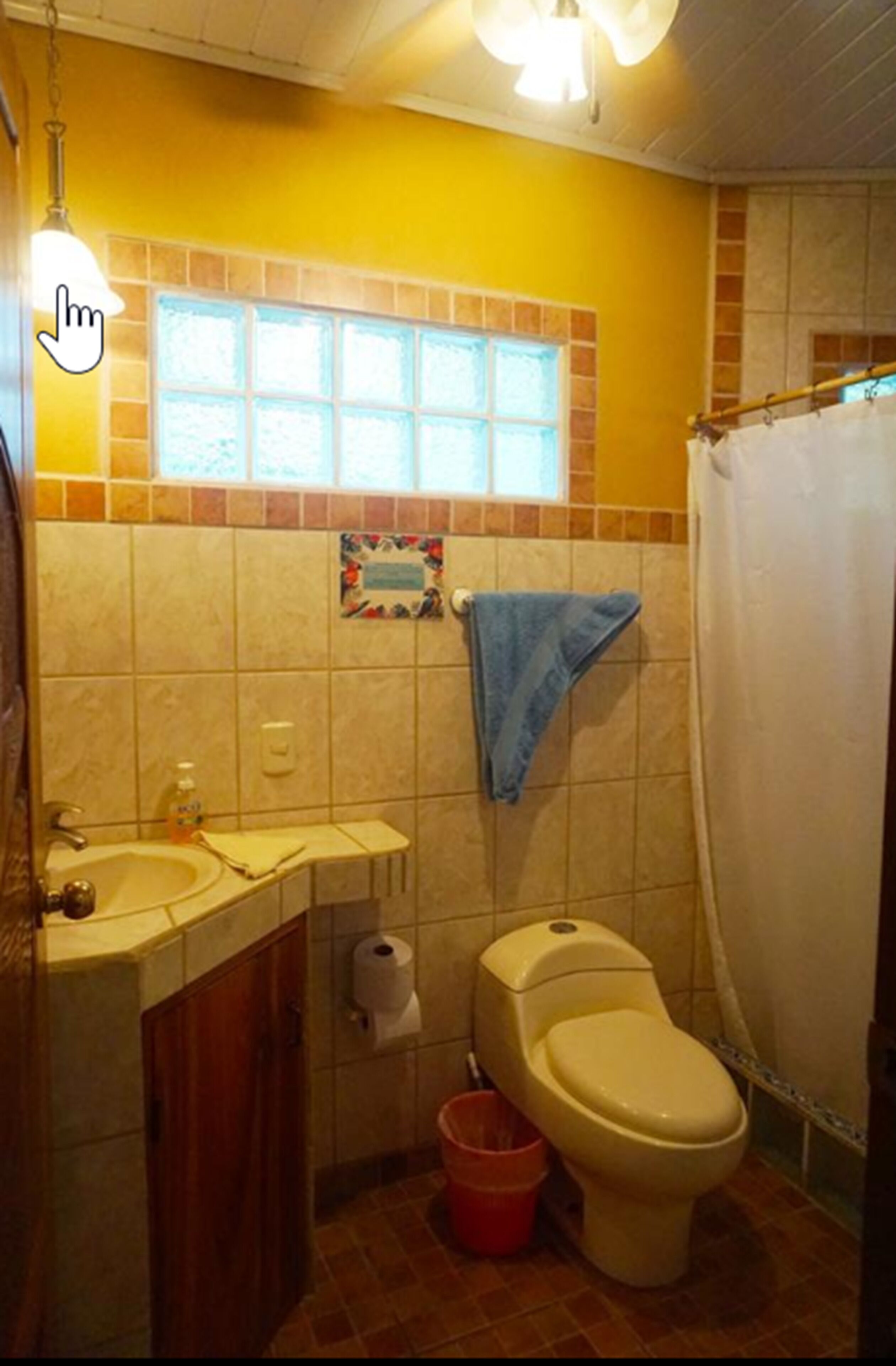 A bathroom with a toilet, sink, and shower curtain.