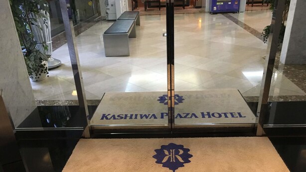 A hotel entrance with a reception desk and a bench. - Kashiwa Plaza Hotel (Kashiwa)