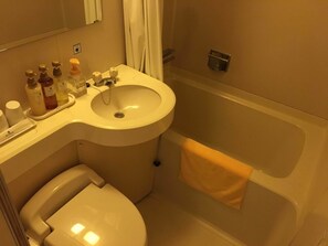 Une salle de bain avec un lavabo, des toilettes et une baignoire.