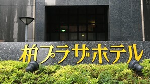 A building entrance with a sign in Japanese characters, a window, and a lamp post. - Kashiwa Plaza Hotel (Kashiwa)